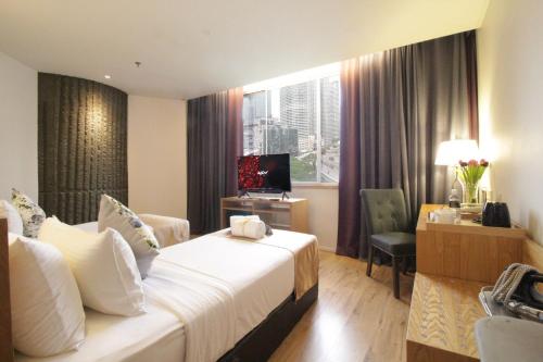 a hotel room with a bed and a desk at de King Boutique Hotel KLCC in Kuala Lumpur