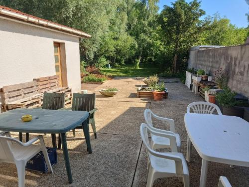 d'une terrasse avec des tables, des chaises, une table et des chaises. dans l'établissement Single bed with a large desk, à Fruges