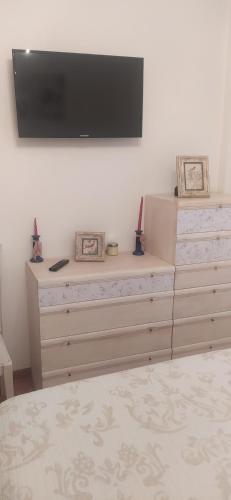 a bedroom with a dresser with a television on the wall at Casa Chus in Foz