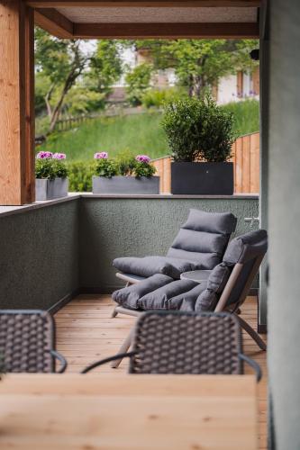 a row of chairs sitting on top of a balcony at Max Green Wood Apartments in Siusi