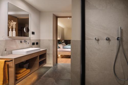 La salle de bains est pourvue d'un lavabo et d'une douche. dans l'établissement Max Green Wood Apartments, à Alpe di Siusi