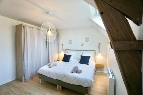 um quarto com uma cama branca e almofadas azuis em Villa Ar Maen em Concarneau