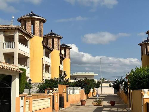 Casa Castillo Penthouse with balcony and solarium near La Zenia boulevard في أوريويلا: صف من المباني عليها قباب