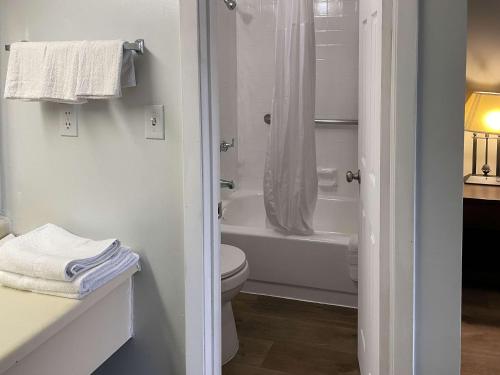 a white bathroom with a toilet and a bath tub at Motel 6 Wytheville VA in Wytheville