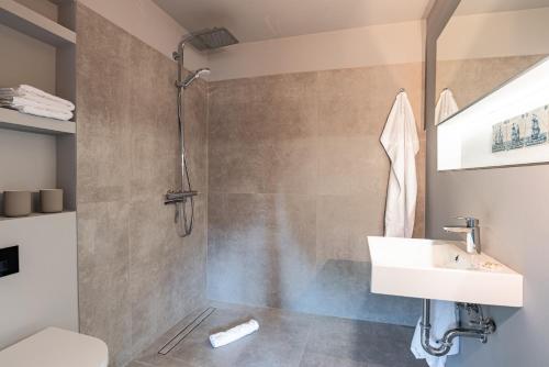La salle de bains est pourvue d'un lavabo et d'une douche. dans l'établissement Nannings Huis, à Oevenum