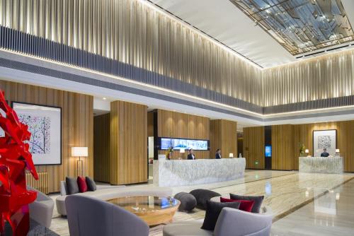 a lobby with chairs and a table in a building at Northern Hotel Shanghai in Shanghai