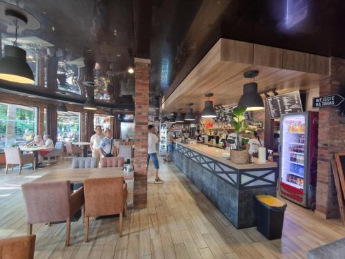 a restaurant with a bar and people sitting at tables at Ośrodek Promenada- Horyzont in Jastrzębia Góra