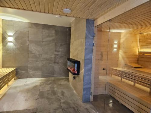 uma sauna com uma televisão na parede em Green Port SPA & Wellness Apartament 218 Kołobrzeg em Kolobrzeg