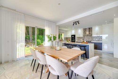 a kitchen and dining room with a wooden table and chairs at VACATION MARBELLA I Villa Nadal, Private Pool, Lush Garden, Best Beaches at Your Doorstep in Marbella