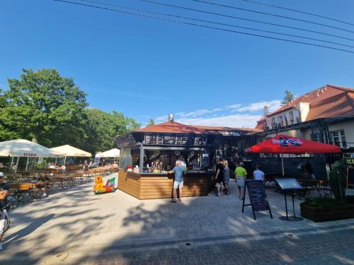 a group of people walking around a market with umbrellas at Ośrodek Promenada- Faleza in Jastrzębia Góra