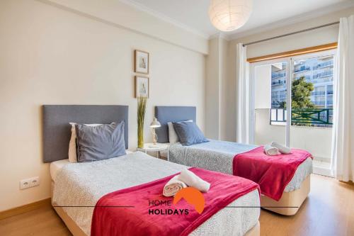 a bedroom with two beds and a window at #032 T2 Idalia by Home Holidays in Albufeira
