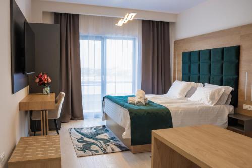 una camera d'albergo con letto e TV di M City Aparthotel a Arad