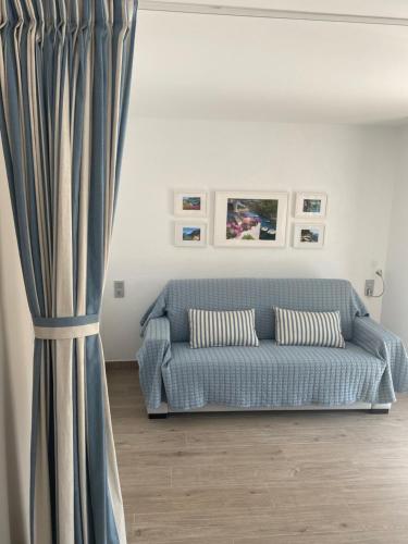 a blue couch in a living room with a curtain at Loft Los Caracoles in Palamós