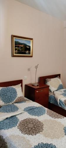 a bedroom with two beds and a picture on the wall at Villa Mia Suites in Ohrid