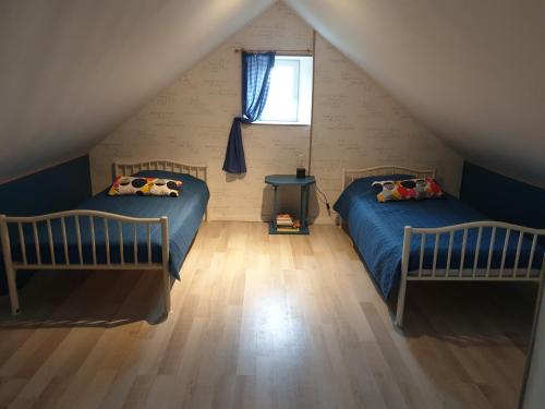 Écrammeville的住宿－Ferme de Barville & SPA，阁楼卧室设有两张床和窗户。