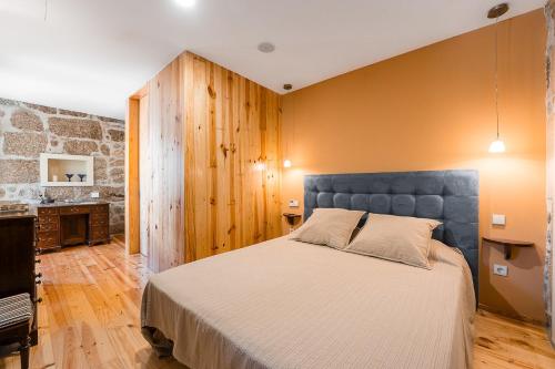 a bedroom with a large bed and a fireplace at Casa do Pomar - Manor House in Taide