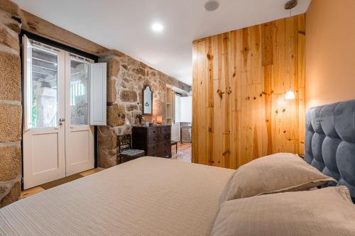 a bedroom with a bed and a stone wall at Stone-crafted tranquility with a relaxing pool in Taide