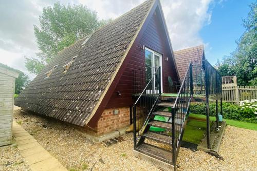 a small house with a staircase in front of it at River Lark Lodge in Ely