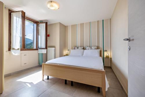 a bedroom with a bed and a large window at Appartamento Le Coste piano terra in Tignale