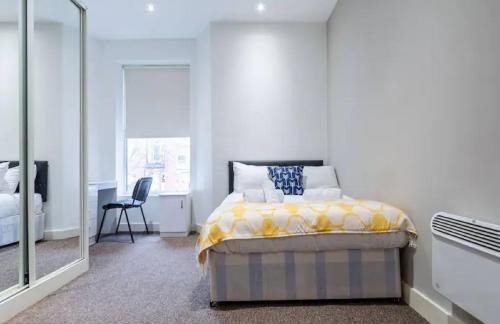a bedroom with a bed and a large mirror at Kelvin Grove by UStay in Liverpool
