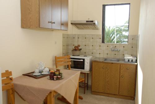 a small kitchen with a table and a microwave at 'Αγριοι Λιμένες in Iria