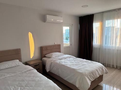 a bedroom with two beds and a window at Lumiera Suites Hotel in Nilüfer