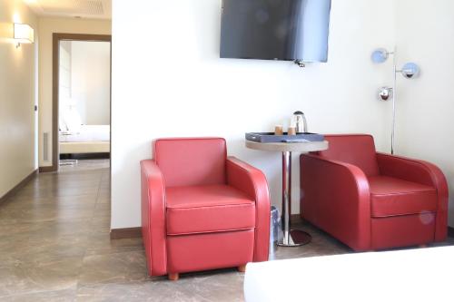 two red chairs and a table in a room at Klima Hotel Milano Fiere in Milan