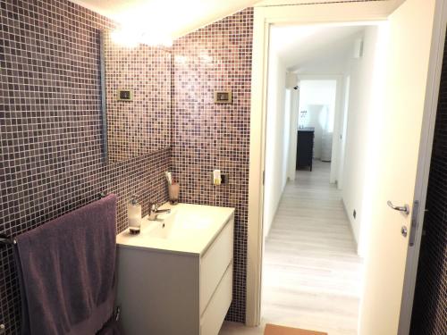 a bathroom with a sink and tiled walls at Casa vacanze da Giovanni in Marina di Ragusa