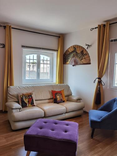 a living room with a couch and a purple ottoman at Le Clos des Consuls in Tarascon