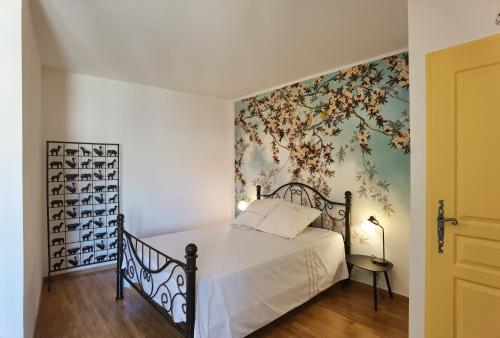 - une chambre avec un lit et un papier peint floral dans l'établissement Le Clos des Consuls, à Tarascon