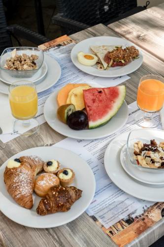 a table with plates of breakfast foods on it at Hotel Cristallo in Rimini