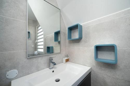 een badkamer met een witte wastafel en een spiegel bij Karédor-Appartement 4 personnes , proche du centre-ville de Saint-Denis in Saint-Denis