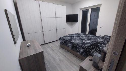 ein Schlafzimmer mit einem Bett und einem TV in der Unterkunft La Perla in Castel San Giorgio