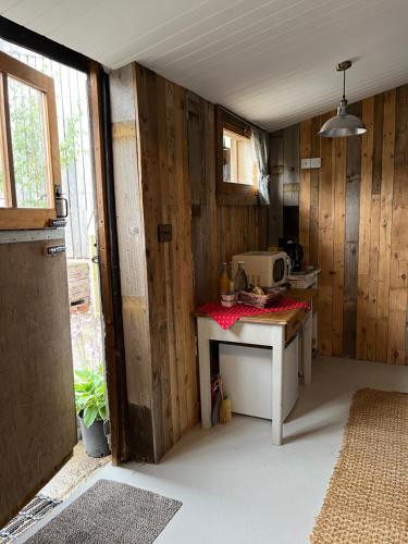 una cucina con pareti in legno e un tavolo in una stanza di The Pig and Sty a Hereford