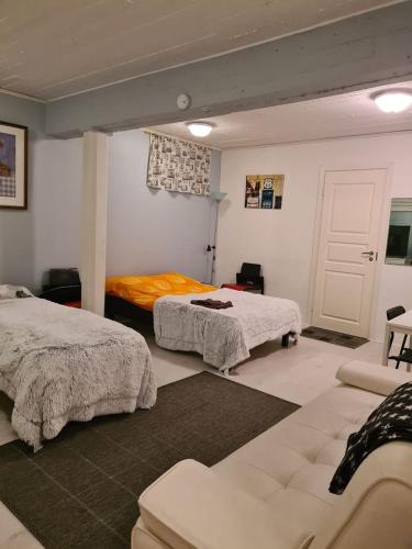 a bedroom with two beds and a couch in it at Hostelli Karvia in Karvia