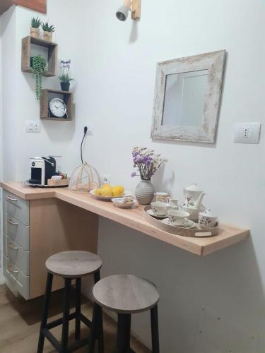 a kitchen with a counter with two stools and a sink at SARDEGNA DEL NORD - BELLISSIMA CASA CON TERRAZZA - INTERNET Wifi in Laerru