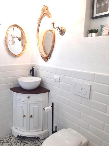 a bathroom with a sink and two mirrors on the wall at SARDEGNA DEL NORD - BELLISSIMA CASA CON TERRAZZA - INTERNET Wifi in Laerru