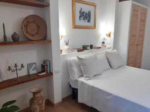 1 dormitorio con cama blanca y almohadas blancas en Nuovissima Casa in Sardegna!!!!!!!, en Laerru