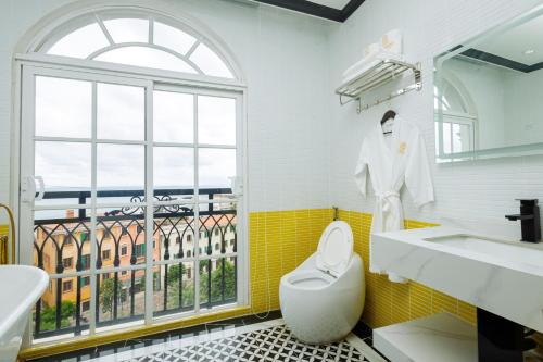 La salle de bains est pourvue d'un lavabo, de toilettes et d'une fenêtre. dans l'établissement De Stefano Coffee and Hotel, à Duong Dong