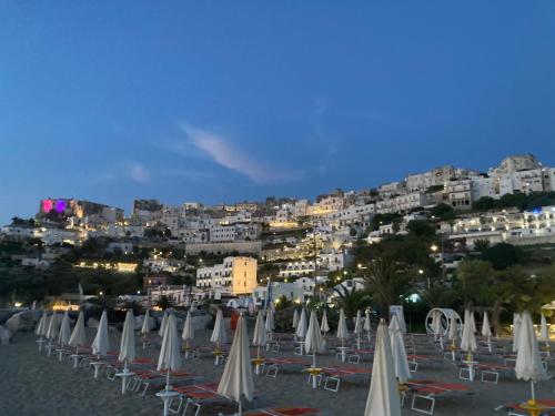 a group of chairs and umbrellas on a beach at Montebello Luxury Apartment in Peschici