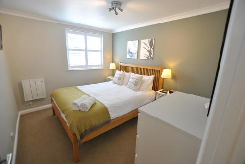 a small bedroom with a bed and two windows at One Bedroom Central Windsor Flats with Parking in Windsor