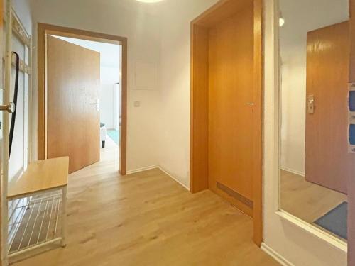 ein leeres Zimmer mit einem Flur mit Tür und Holzböden in der Unterkunft Nice Apartment in Bernau in Bernau bei Berlin