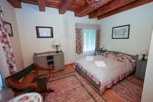 a bedroom with a bed and a desk and a chair at Wenckheim Vadászház in Nagyoroszi