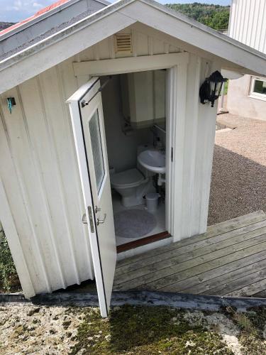 a white shed with a toilet inside of it at Nösund Orust Lilla Huset in Nösund