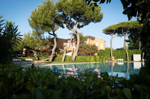 a swimming pool with trees and a house in the background at Appartamento Garuda20 in Cavallino-Treporti