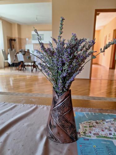 a vase filled with purple flowers sitting on a table at Mara in Zadar