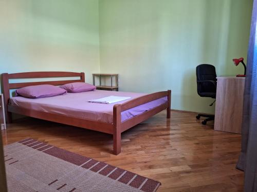 a bedroom with a bed with purple pillows and a desk at Mara in Zadar