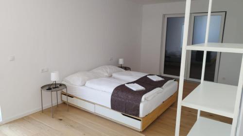 a white bedroom with a bed and a mirror at Haus mit Garten bei Wien in Langenzersdorf