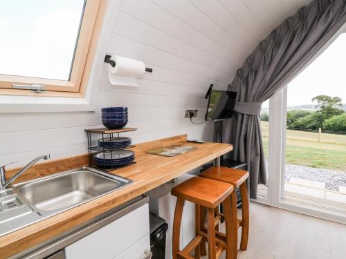 een keuken in een tiny house met een wastafel en een raam bij Ash in Saltash