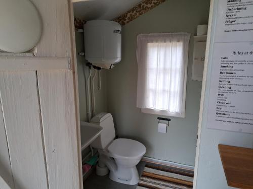 a small bathroom with a toilet and a window at Hästveda Vandrarhem och Stugor in Hästveda